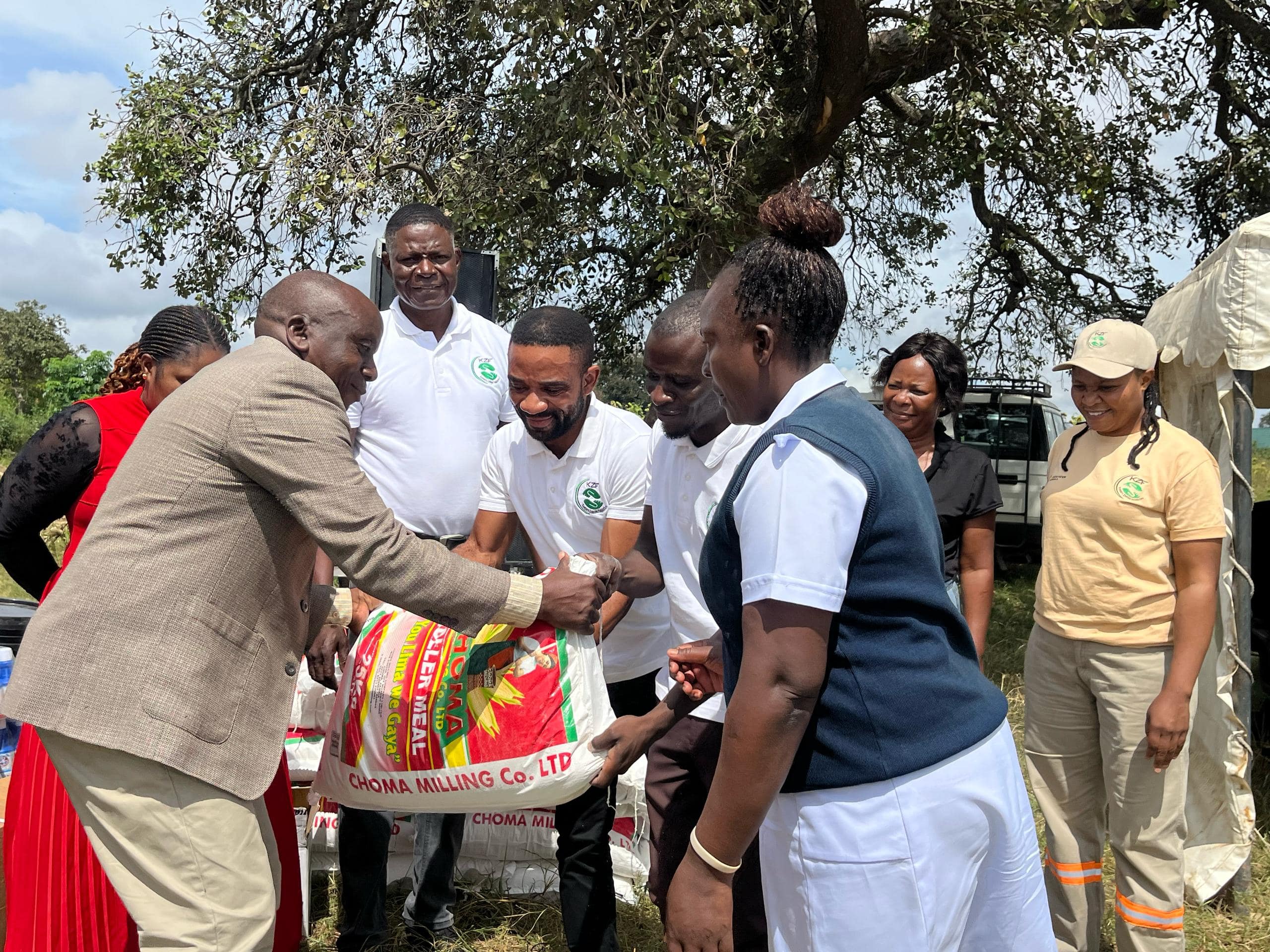 District official handing over a bag of mealie meal to beneficiaries during a KZF distribution event