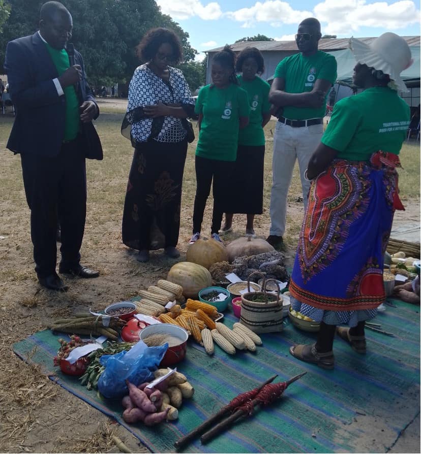 District Commissioner in In Blue jacket, District Agriculture Coordinator next to DC and KZF Director inspects variety of exhibits