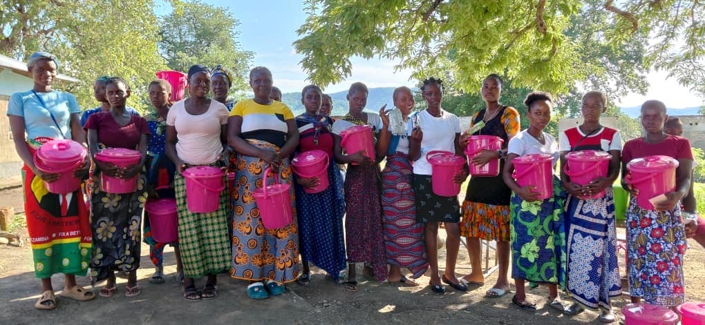 Group of women holding water buckets during WASH distribution in Zambia